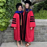 Two Cornell PhD graduates in regalia 